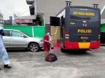 Seorang pasien isoman saat dijemput dan dipindahkan ke tempat isolasi pemerintah oleh pihak kepolisian